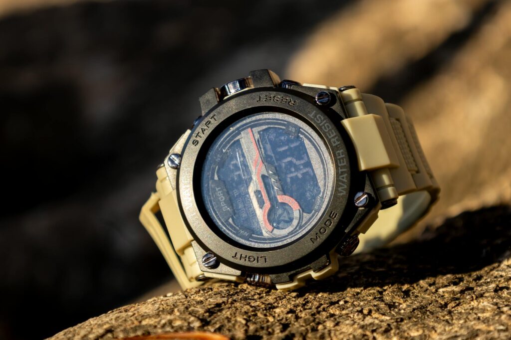 Close-up of a rugged sports watch, perfect for outdoor adventures, resting on a rock.