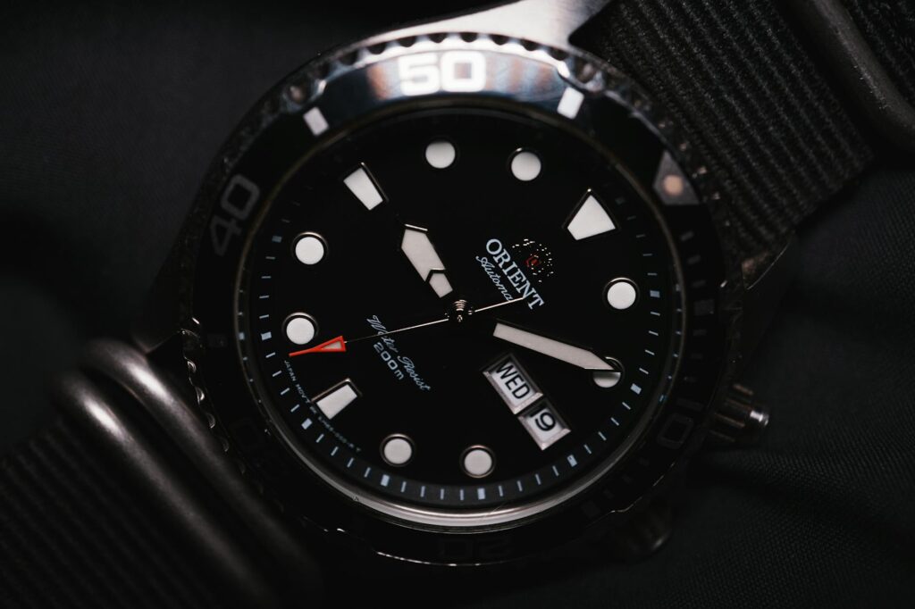 Detailed close-up of an Orient brand diving wristwatch with date feature displayed.