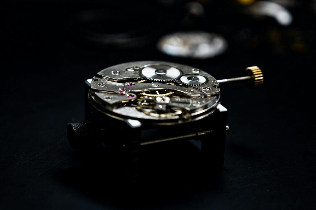 Close-up of a detailed watch mechanism showcasing gears and components against a dark background.
